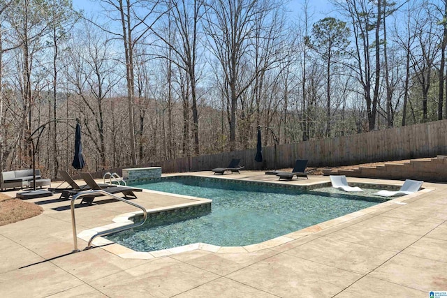 view of pool with a hot tub, a fenced backyard, a fenced in pool, and a patio