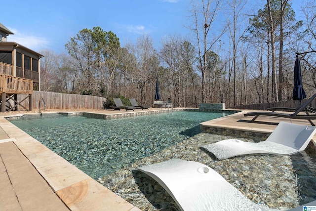 pool with a patio area, fence, and a sunroom