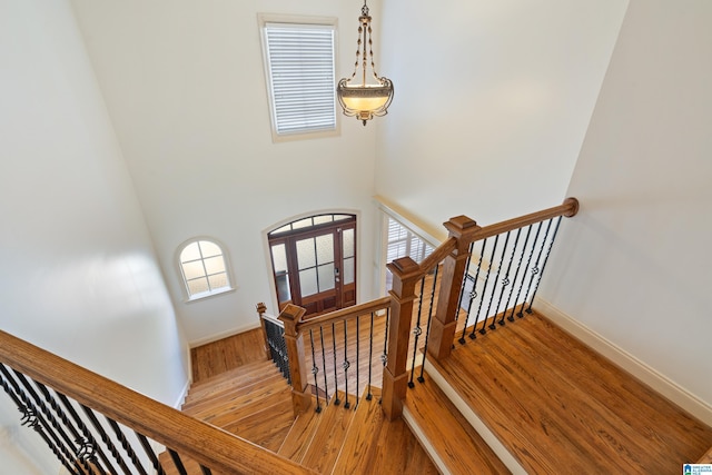 stairs with plenty of natural light, baseboards, and wood finished floors