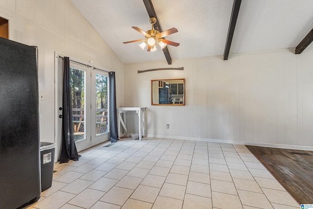 unfurnished room with vaulted ceiling with beams, light tile patterned floors, ceiling fan, a textured ceiling, and baseboards