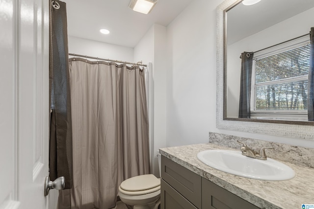 full bath with curtained shower, vanity, and toilet