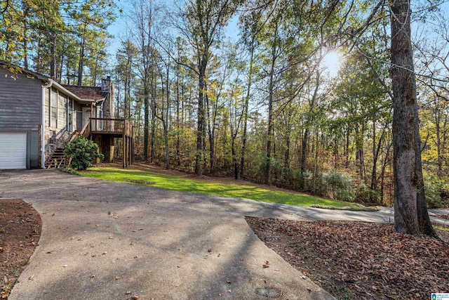 view of yard with stairs and concrete driveway