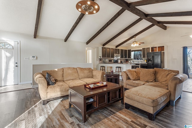 living room featuring lofted ceiling with beams, ceiling fan, and wood finished floors