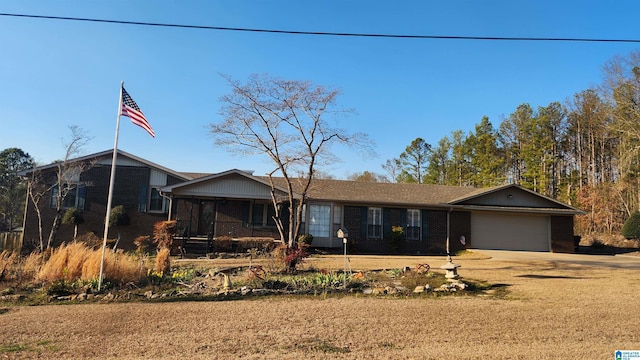 ranch-style home featuring dirt driveway, brick siding, and a garage