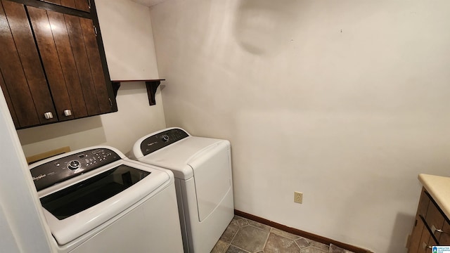 laundry area with washing machine and dryer, cabinet space, and baseboards