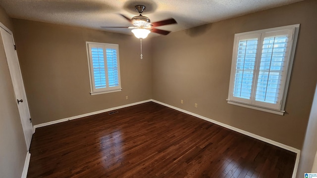 unfurnished bedroom with baseboards, dark wood finished floors, and a textured ceiling