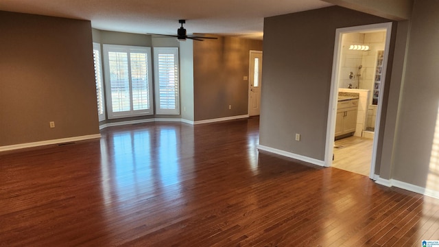 spare room featuring ceiling fan, baseboards, and wood finished floors