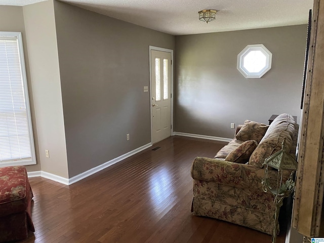 entryway featuring visible vents, a textured ceiling, baseboards, and wood finished floors