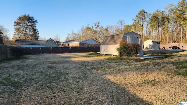 view of yard with an outbuilding, a storage unit, and a fenced backyard