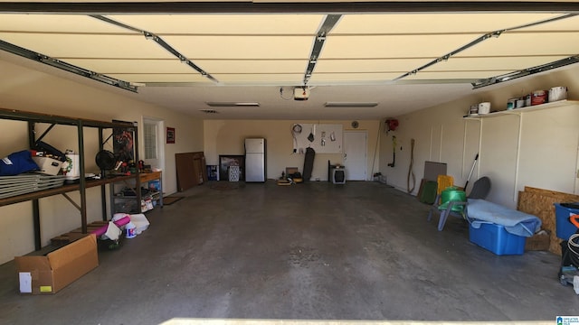 garage with a garage door opener and freestanding refrigerator