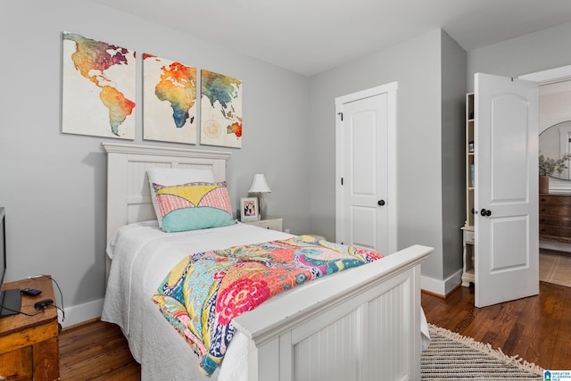 bedroom with dark wood-style flooring and baseboards