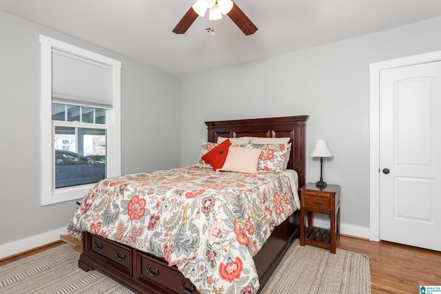 bedroom featuring a ceiling fan, light wood-style flooring, and baseboards