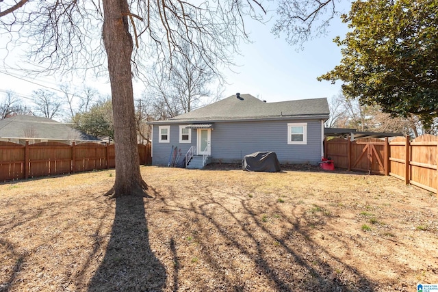 back of property with entry steps and a fenced backyard