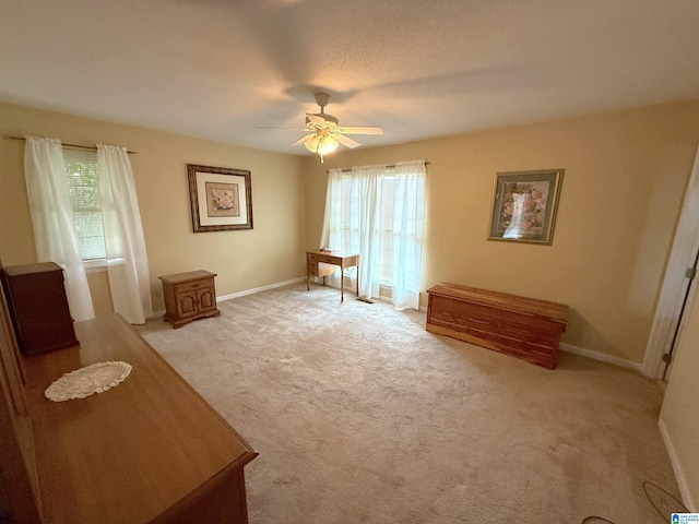 interior space with light colored carpet, ceiling fan, and baseboards