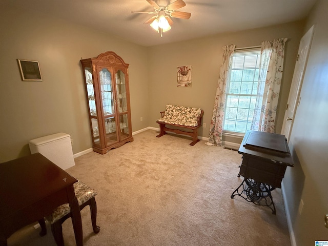 living area with carpet floors, baseboards, and a ceiling fan