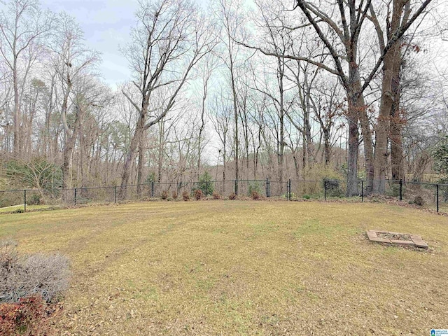 view of yard with a fenced backyard and a view of trees