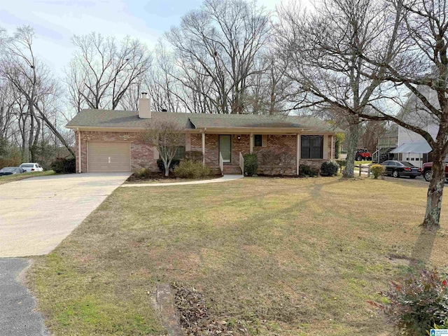 view of front of house with driveway, a garage, brick siding, a chimney, and a front yard