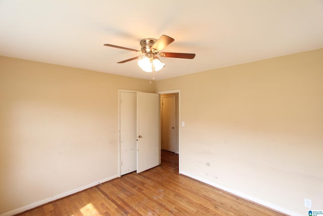 spare room featuring light wood-style floors, baseboards, and a ceiling fan