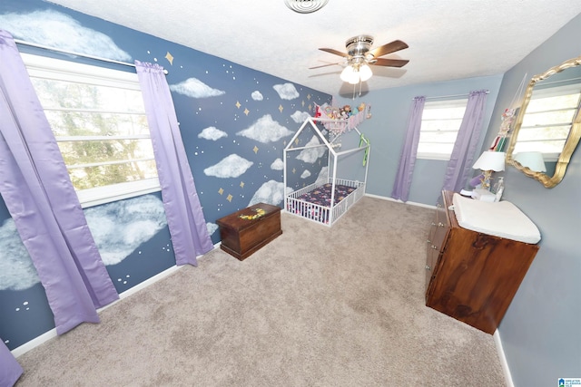 bedroom with a ceiling fan, carpet, a textured ceiling, and baseboards