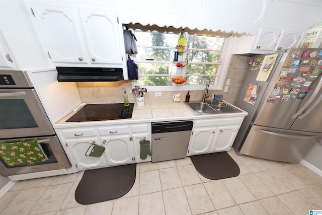 kitchen with white cabinets, under cabinet range hood, stainless steel appliances, and a sink