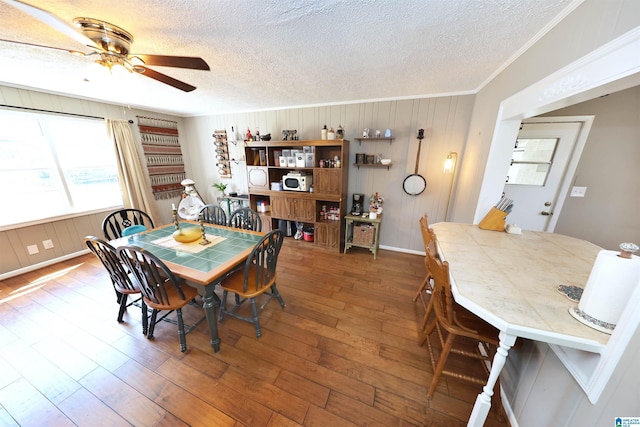 dining space featuring crown molding, a textured ceiling, ceiling fan, and hardwood / wood-style floors