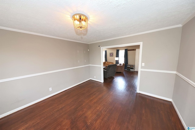 spare room featuring crown molding, baseboards, a chandelier, and wood finished floors