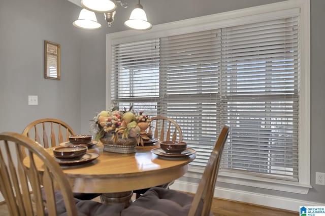 dining room featuring an inviting chandelier, baseboards, and wood finished floors