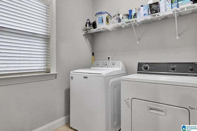 laundry room with laundry area, washing machine and dryer, and baseboards