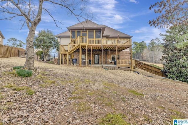 back of property featuring roof with shingles, stairway, a sunroom, a deck, and a fenced backyard