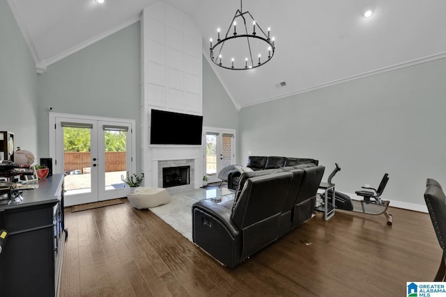 living area featuring high vaulted ceiling, wood finished floors, french doors, a fireplace, and crown molding