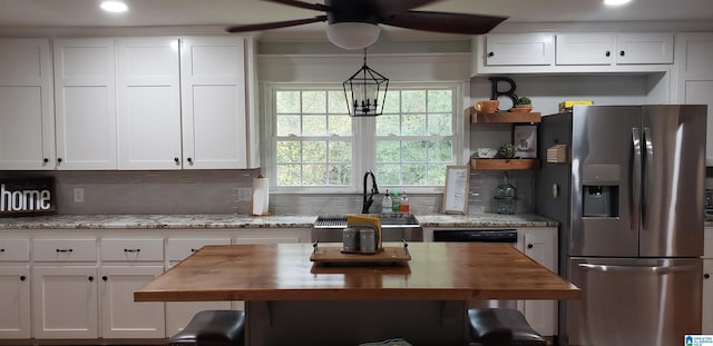 kitchen featuring backsplash, stainless steel fridge, wood counters, and white cabinetry