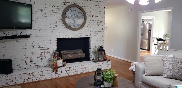 living room featuring a fireplace, wood finished floors, and baseboards