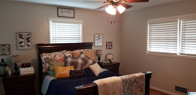 bedroom with a ceiling fan, visible vents, and baseboards