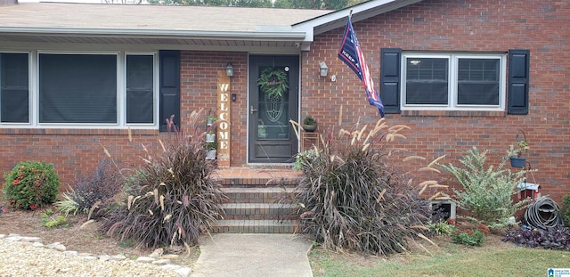 view of exterior entry with brick siding