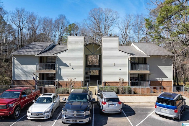 view of building exterior featuring uncovered parking and fence