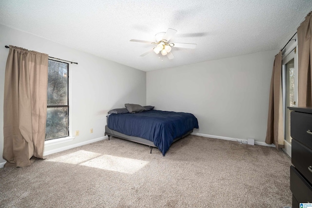 bedroom featuring light carpet, a textured ceiling, and baseboards