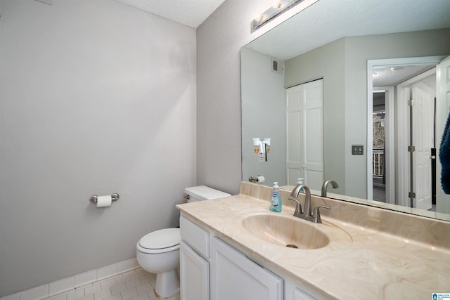 bathroom featuring visible vents, toilet, a textured ceiling, baseboards, and tile patterned floors