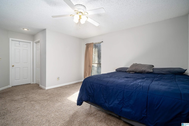 carpeted bedroom featuring ceiling fan, baseboards, and a textured ceiling