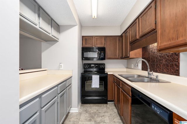 kitchen with a textured ceiling, a sink, light countertops, backsplash, and black appliances