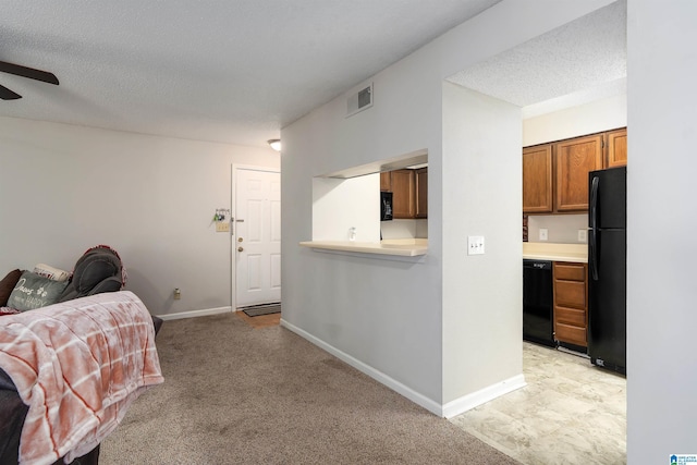 bedroom with a textured ceiling, light colored carpet, visible vents, baseboards, and freestanding refrigerator