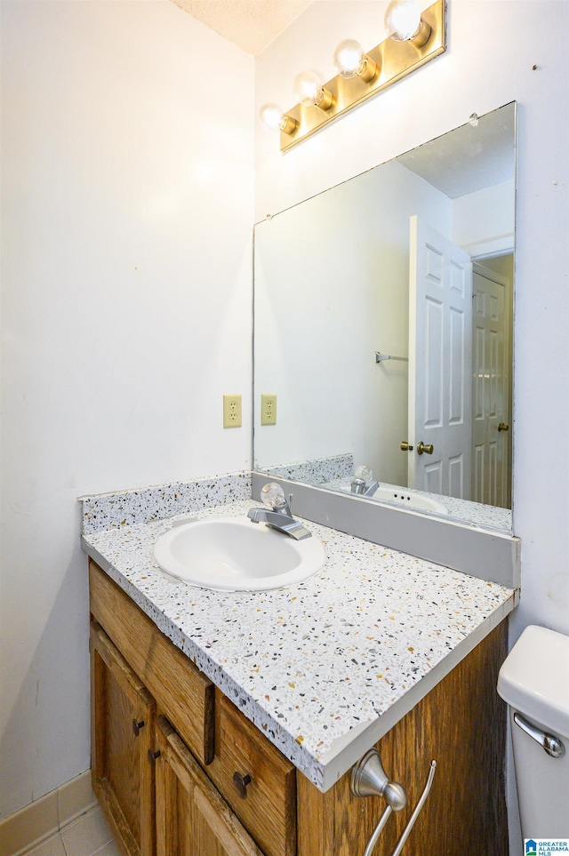 half bath with tile patterned flooring, vanity, and toilet