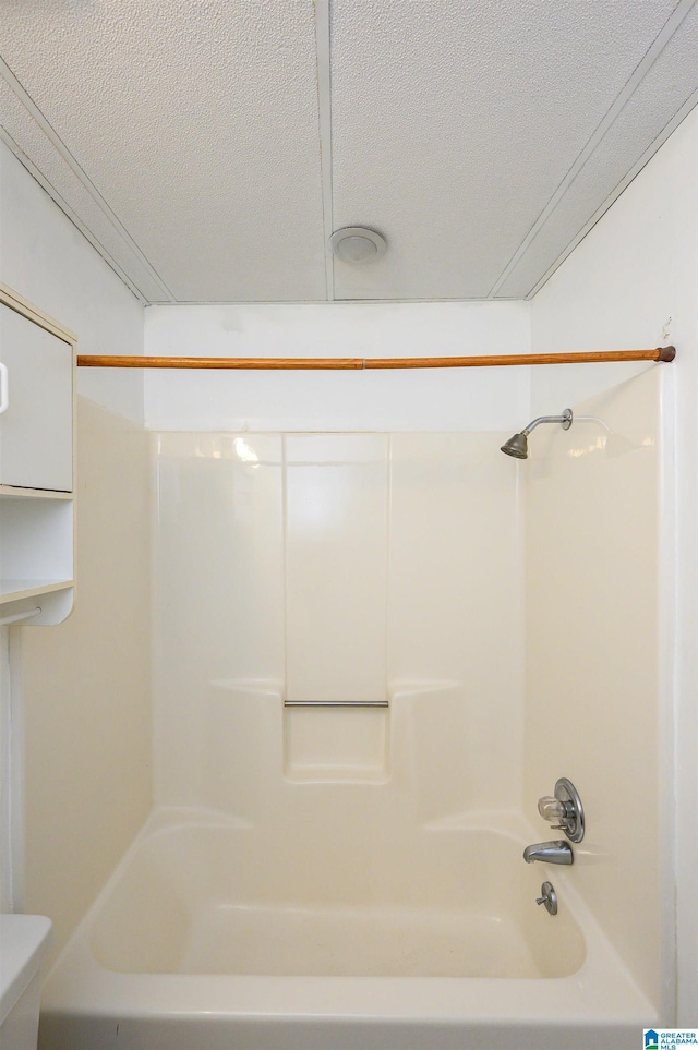 full bath with toilet, bathtub / shower combination, and a textured ceiling