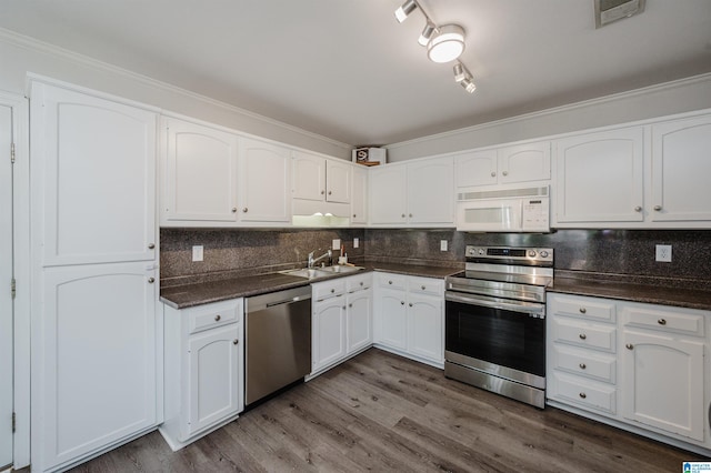 kitchen featuring white cabinetry, appliances with stainless steel finishes, dark wood finished floors, and a sink