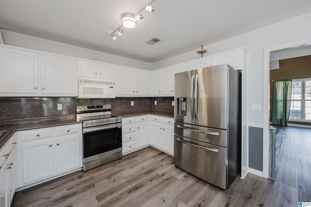 kitchen with stainless steel appliances, visible vents, white cabinetry, tasteful backsplash, and dark countertops