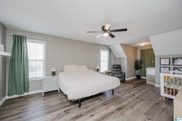 bedroom featuring lofted ceiling, ceiling fan, wood finished floors, and baseboards