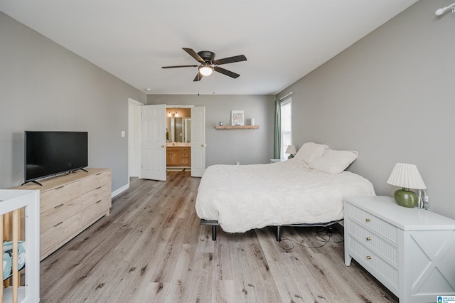 bedroom with light wood-type flooring, ensuite bath, a ceiling fan, and baseboards