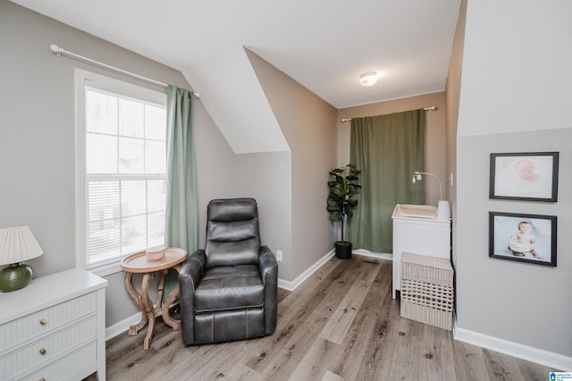 sitting room featuring lofted ceiling, light wood-type flooring, baseboards, and a wealth of natural light