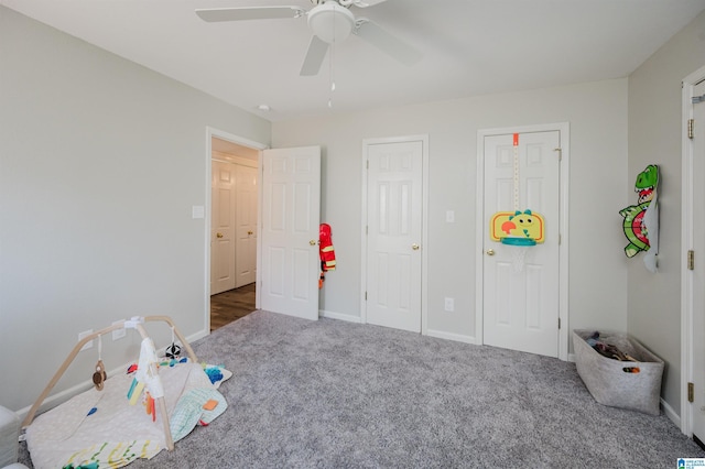 playroom featuring carpet flooring, a ceiling fan, and baseboards