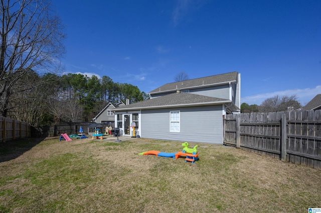 rear view of house featuring a lawn, a patio area, and a fenced backyard