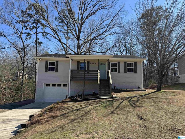 ranch-style house featuring a porch, an attached garage, a front lawn, and driveway